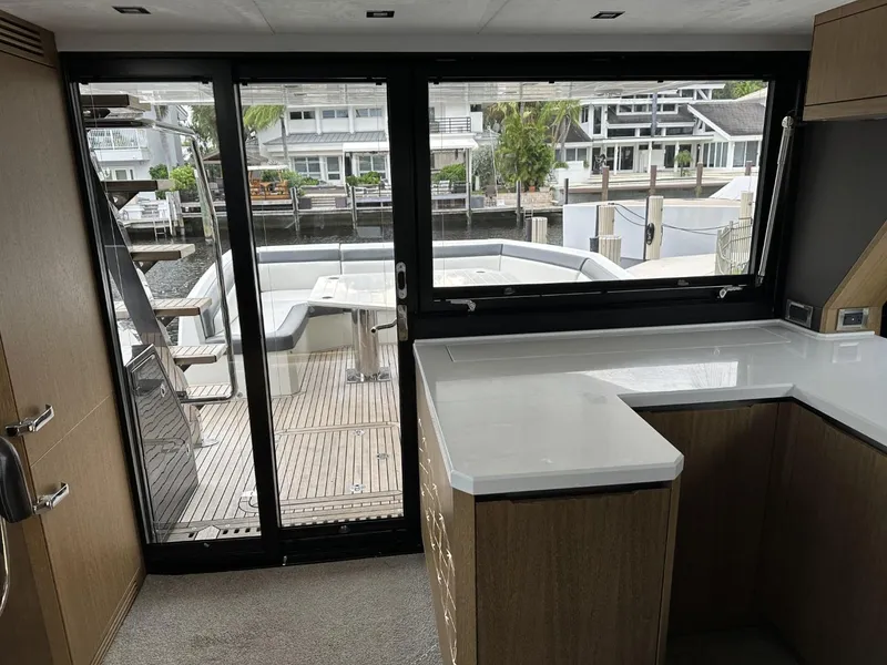 Slide: The Image of Interior view of 2019 Galeon 650 Sky yacht with modern kitchen and deck access. - 49