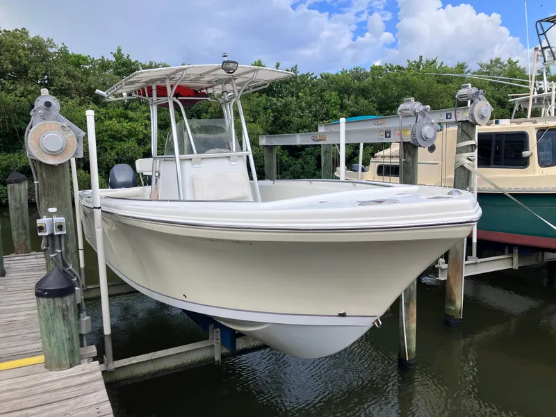 Slide: The Image of 2005 Sailfish 266 CC boat docked at marina with lush greenery. - 10