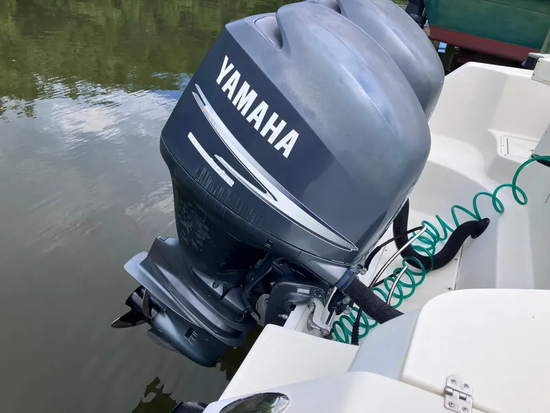 Slide: The Image of Yamaha outboard motor on 2005 Sailfish 266 CC boat, docked on calm water. - 12