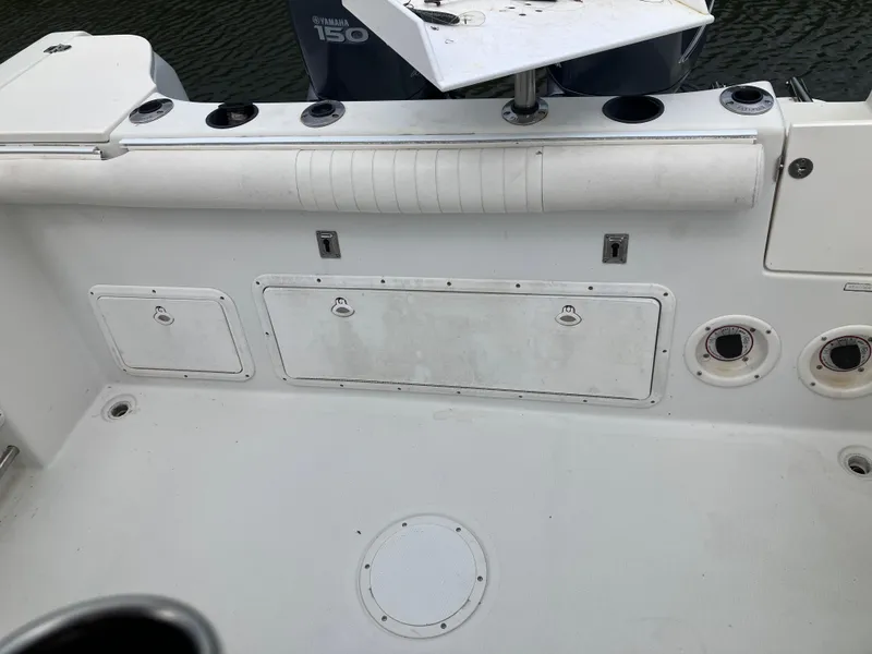 Slide: The Image of 2005 Sailfish 266 CC boat deck with storage compartments and Yamaha 150 engine. - 23