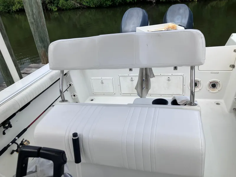 Slide: The Image of 2005 Sailfish 266 CC boat interior with white seating and dual engines. - 28