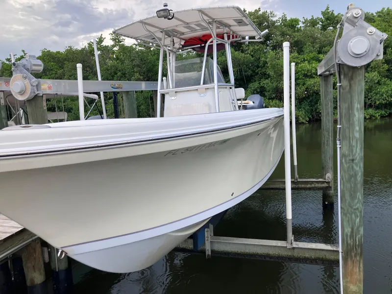 Slide: The Image of 2005 Sailfish 266 CC boat on lift near water and trees. - 3