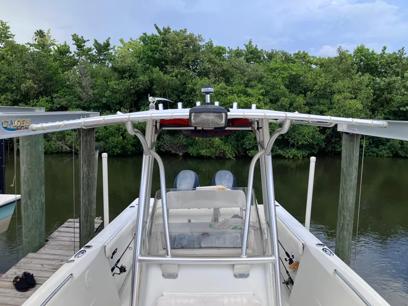 Slide: The Image of 2005 Sailfish 266 CC boat docked near lush greenery. - 30
