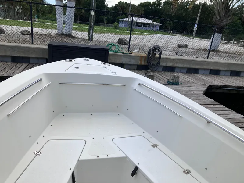 Slide: The Image of 2005 Sailfish 266 CC boat docked, showcasing spacious white interior and sleek design. - 32