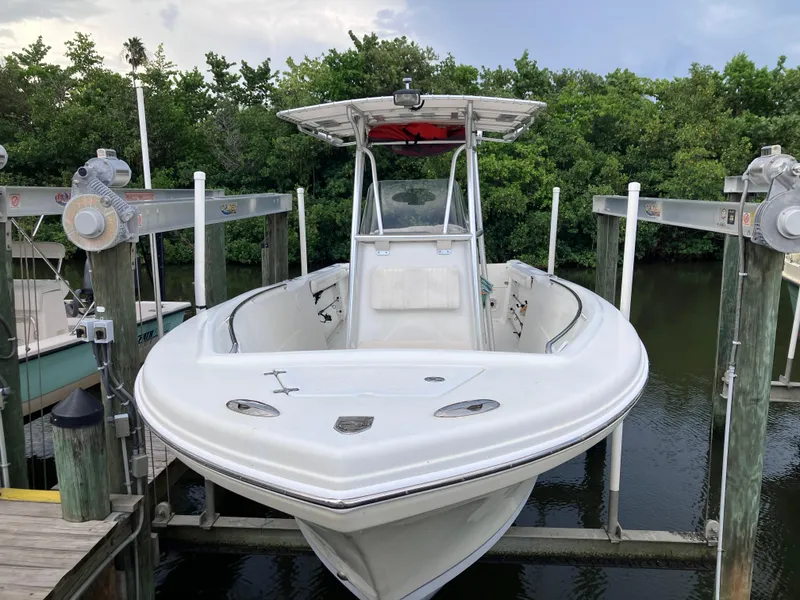 Slide: The Image of 2005 Sailfish 266 CC boat on lift, surrounded by lush greenery. - 4