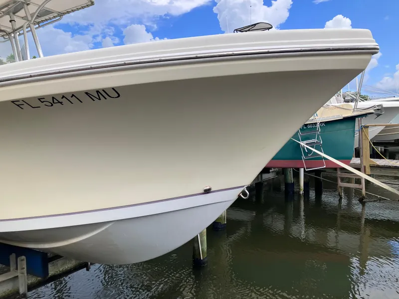 Slide: The Image of 2005 Sailfish 266 CC boat docked, featuring a sleek white hull. - 8