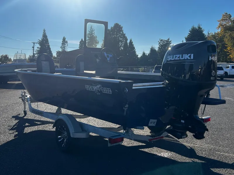 Slide: The Image of 2024 Fish Rite Angler 18 boat with Suzuki motor on trailer, parked outdoors. - 5