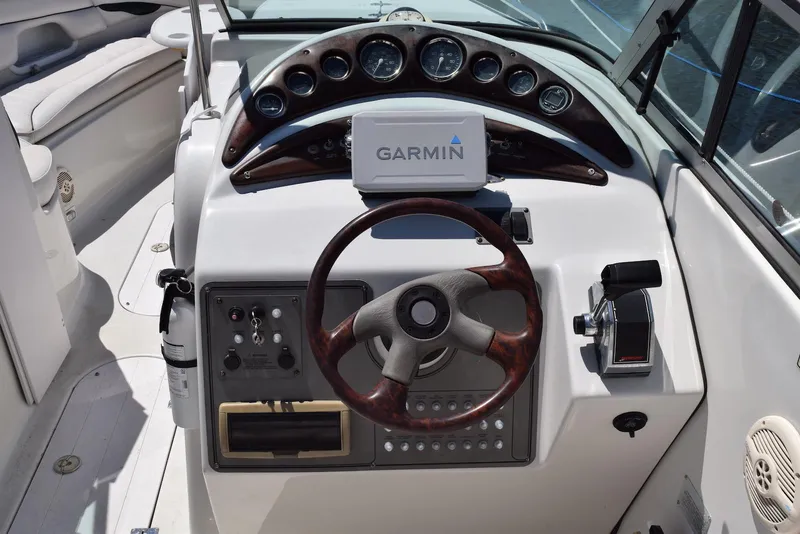 Slide: The Image of Crownline 288 BR 2001 boat dashboard with Garmin GPS and wooden steering wheel. - 11