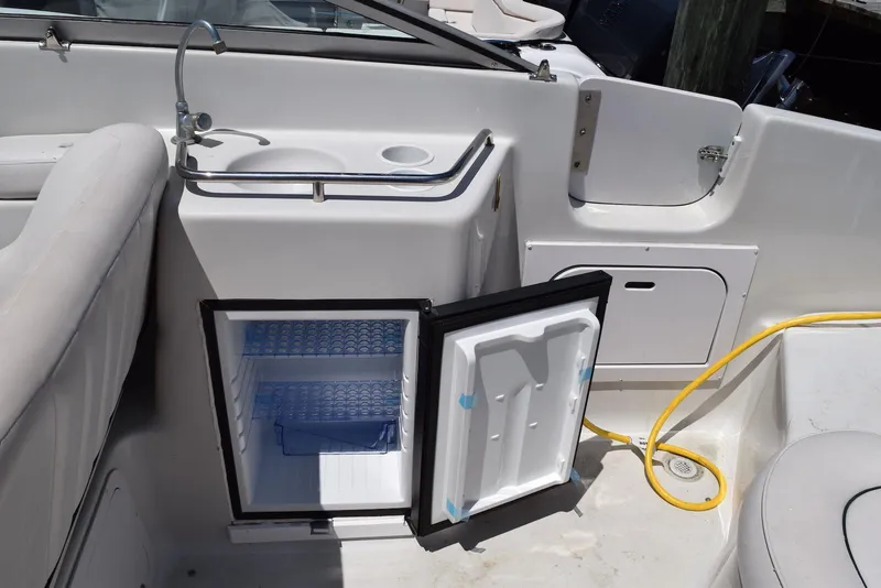 Slide: The Image of 2001 Crownline 288 BR boat interior with open mini fridge and sink. - 12
