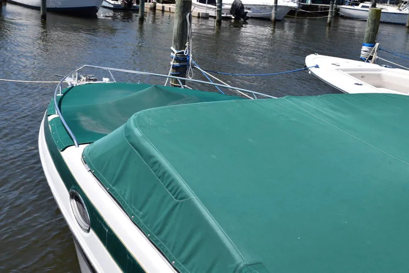 Slide: The Image of Crownline 288 BR 2001 boat with green cover docked at marina. - 22