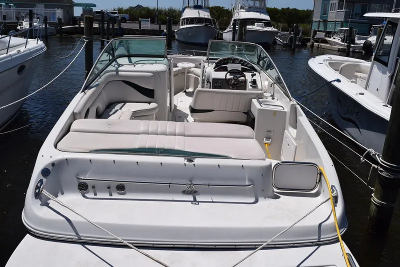 Slide: The Image of 2001 Crownline 288 BR boat docked at marina, featuring spacious seating and sleek design. - 5