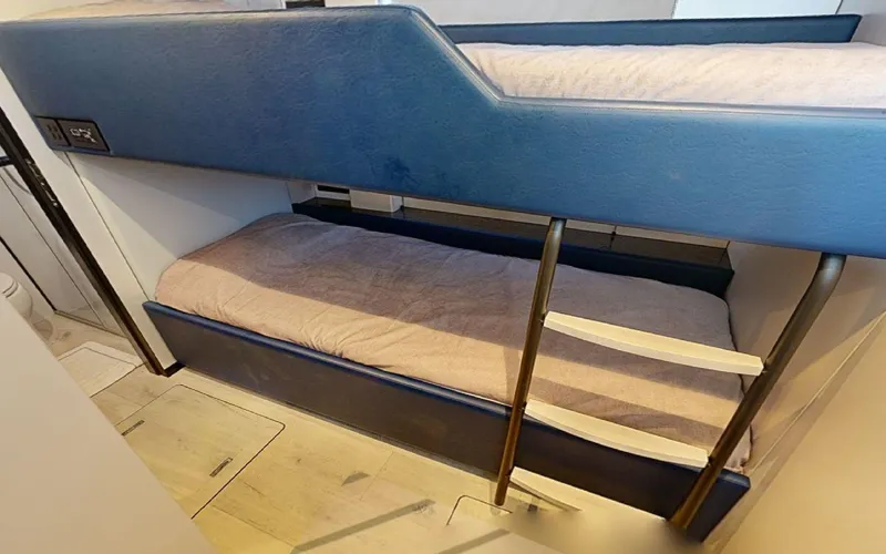 Slide: The Image of Bunk beds in 2024 Sunreef 60 Sail yacht cabin, featuring modern design and cozy bedding. - 13
