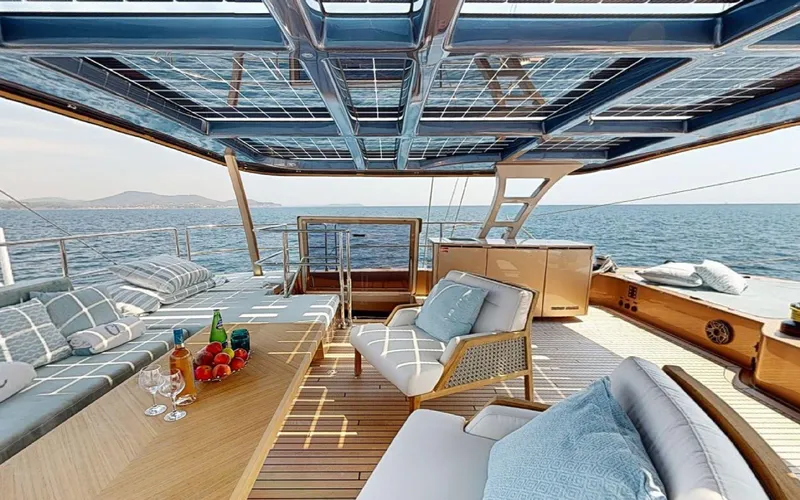 Slide: The Image of Luxurious Sunreef 60 Sail yacht deck with elegant seating, ocean view, and refreshments, 2024 model. - 22