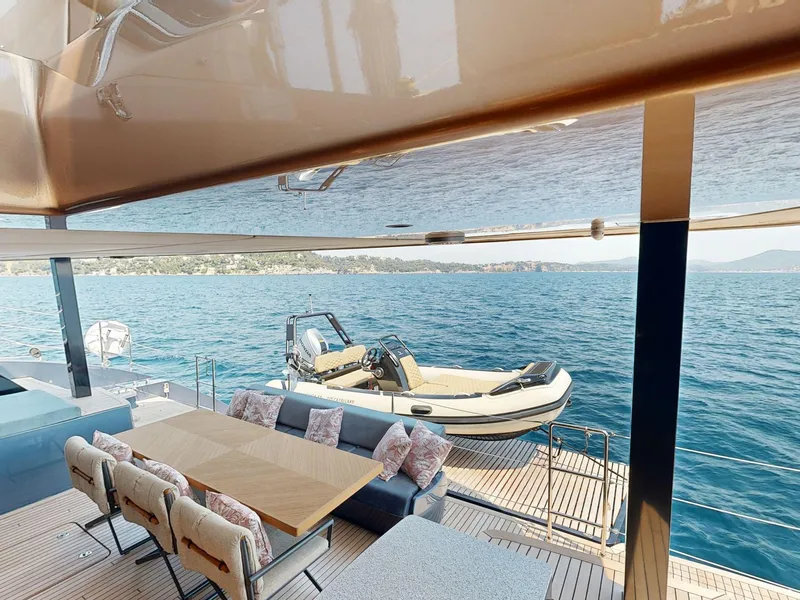 Slide: The Image of Luxurious Sunreef 60 Sail yacht deck with dining area, overlooking serene ocean view, 2024 model. - 24
