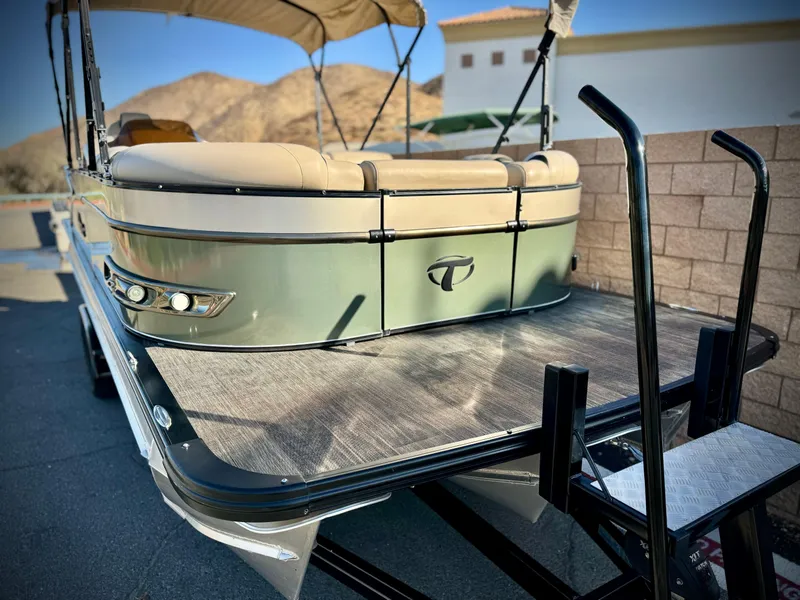 Slide: The Image of 2022 Tahoe Pontoon Cascade Platinum Rear J Lounger with sunshade and ladder, parked outdoors. - 10