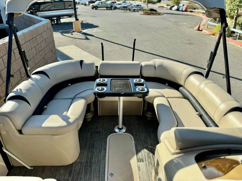 Slide: The Image of 2022 Tahoe Pontoon Cascade Platinum Rear J Lounger with beige seating and table. - 13