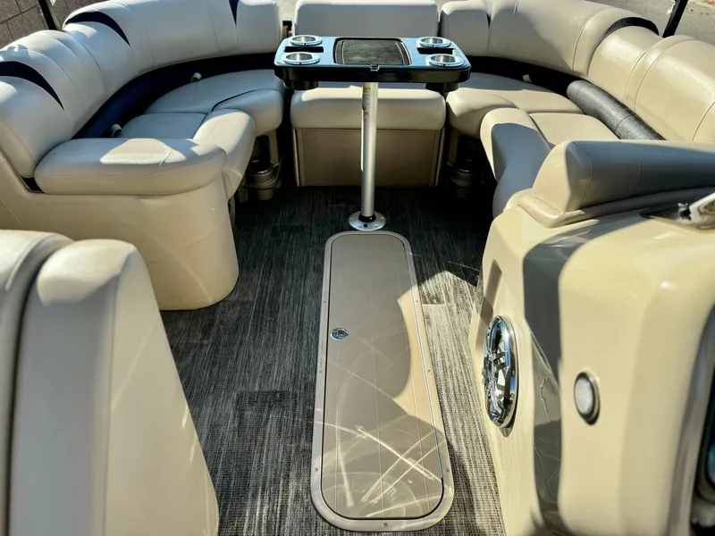 Slide: The Image of 2022 Tahoe Pontoon Cascade Platinum Rear J Lounger interior with plush seating and table. - 14
