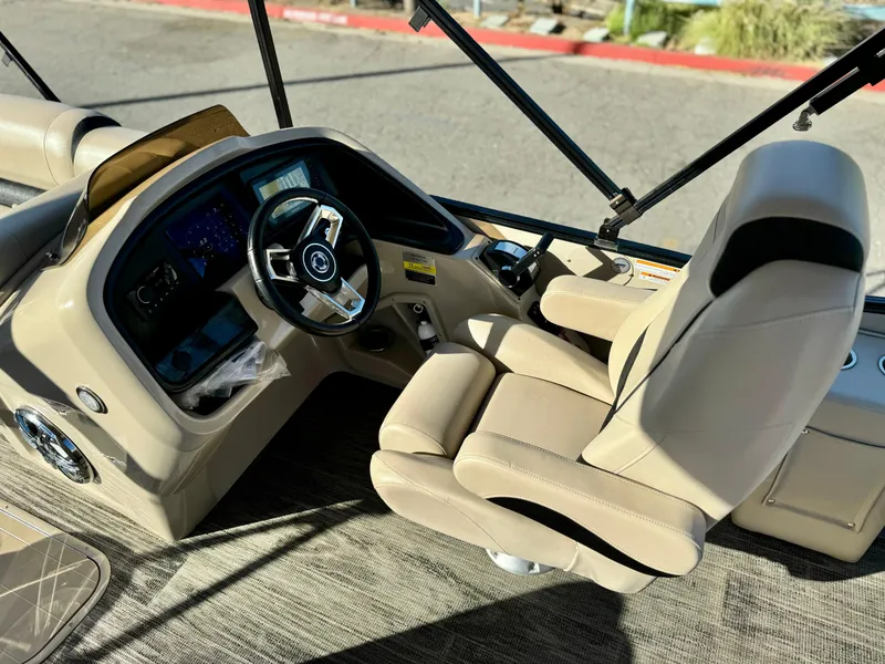 Slide: The Image of 2022 Tahoe Pontoon Cascade Platinum boat interior with steering wheel and captain's chair. - 19