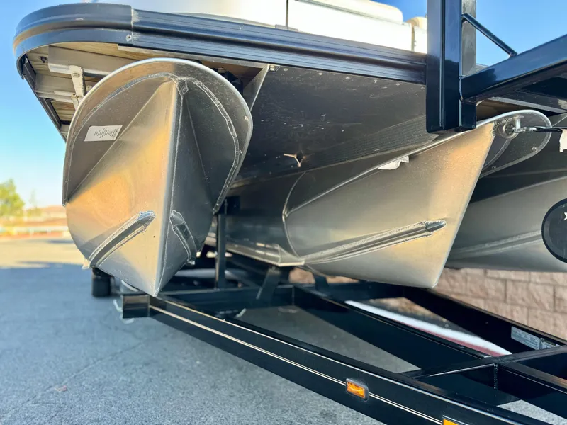 Slide: The Image of 2022 Tahoe Pontoon Cascade Platinum Rear J Lounger on trailer, close-up of pontoons. - 2