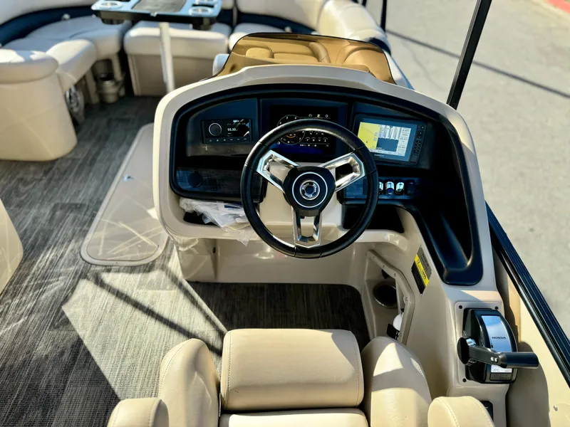 Slide: The Image of 2022 Tahoe Pontoon Cascade Platinum Rear J Lounger interior with steering wheel and seating. - 20