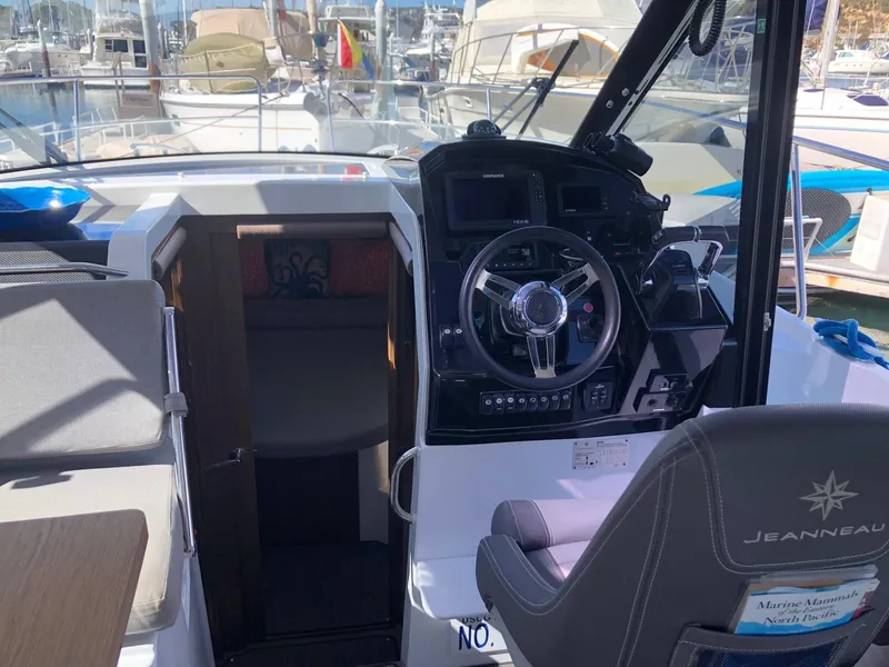 Slide: The Image of 2018 Jeanneau NC 895 boat interior with steering wheel and seating area. - 15
