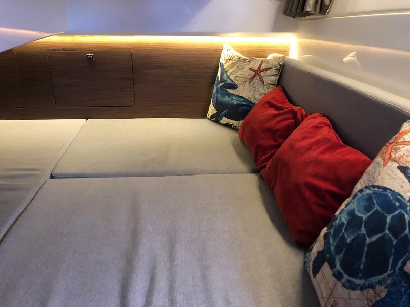 Slide: The Image of Cozy interior of 2018 Jeanneau NC 895 with decorative pillows and ambient lighting. - 19