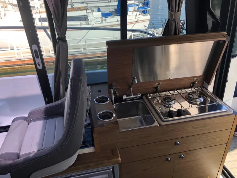 Slide: The Image of Jeanneau NC 895 2018 boat interior with compact kitchen and seating. - 23