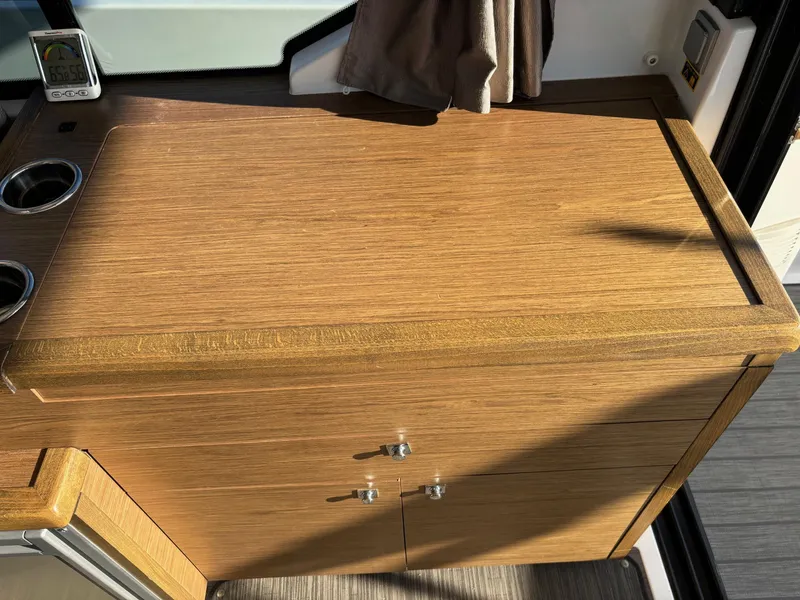 Slide: The Image of Wooden cabinet on 2018 Jeanneau NC 895 boat interior, featuring cup holders and storage. - 24