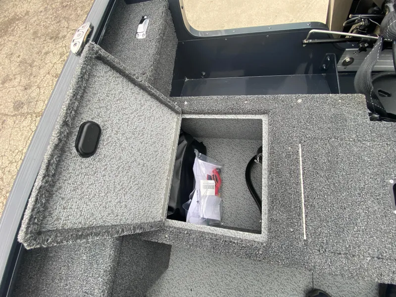 Slide: The Image of 2025 Lund 1775 Pro Guide boat storage compartment with open lid, showing interior space. - 25