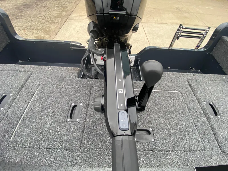 Slide: The Image of 2025 Lund 1775 Pro Guide boat interior with motor controls and carpeted flooring. - 27