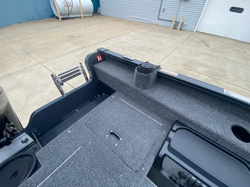 Slide: The Image of 2025 Lund 1775 Pro Guide boat interior with carpeted deck and storage compartments. - 28