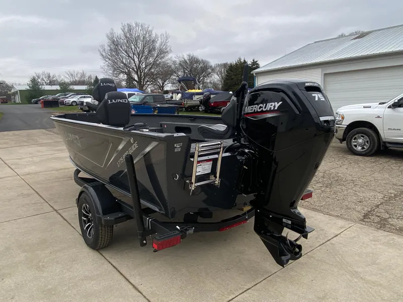 Slide: The Image of 2025 Lund 1775 Pro Guide boat with Mercury 75 engine on a driveway. - 3