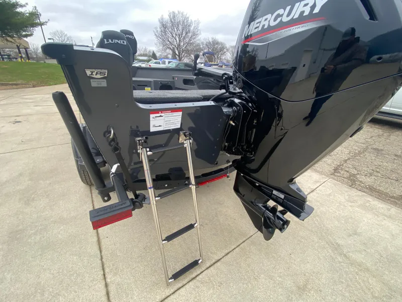 Slide: The Image of 2025 Lund 1775 Pro Guide boat with Mercury engine and ladder on concrete surface. - 30