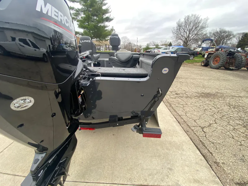 Slide: The Image of 2025 Lund 1775 Pro Guide boat with Mercury engine, parked outdoors. - 31