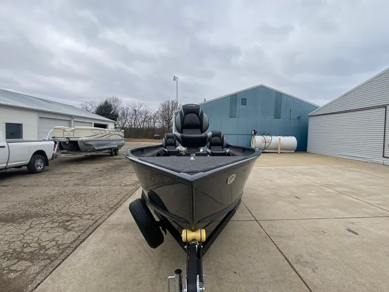 Slide: The Image of 2025 Lund 1775 Pro Guide boat on trailer in industrial yard. - 6