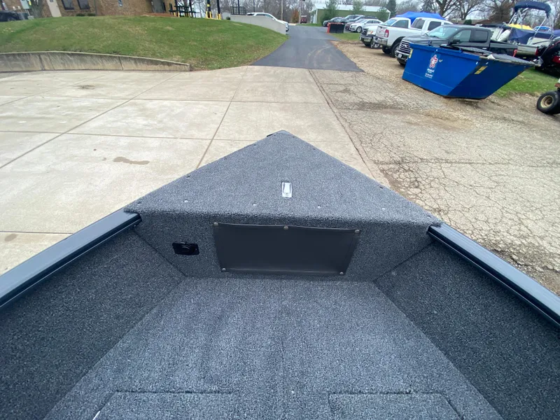 Slide: The Image of 2025 Lund 1775 Pro Guide boat interior with carpeted deck and storage compartment. - 9