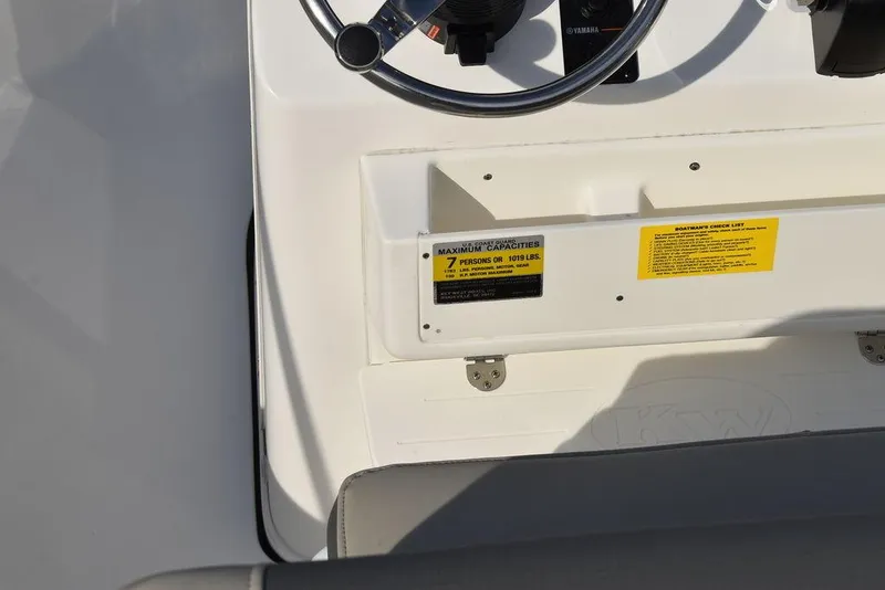 Slide: The Image of Key West 189 FS 2025 boat dashboard with steering wheel and safety labels. - 18