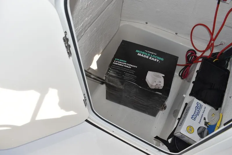 Slide: The Image of Storage compartment in 2025 Key West 189 FS boat with portable toilet and accessories. - 24