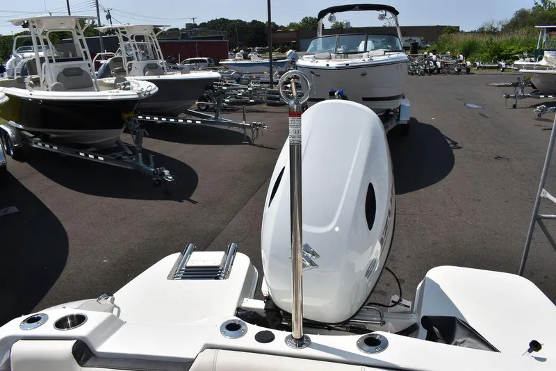 Slide: The Image of 2023 Stingray 191DC boat in a dealership lot with other boats. - 24