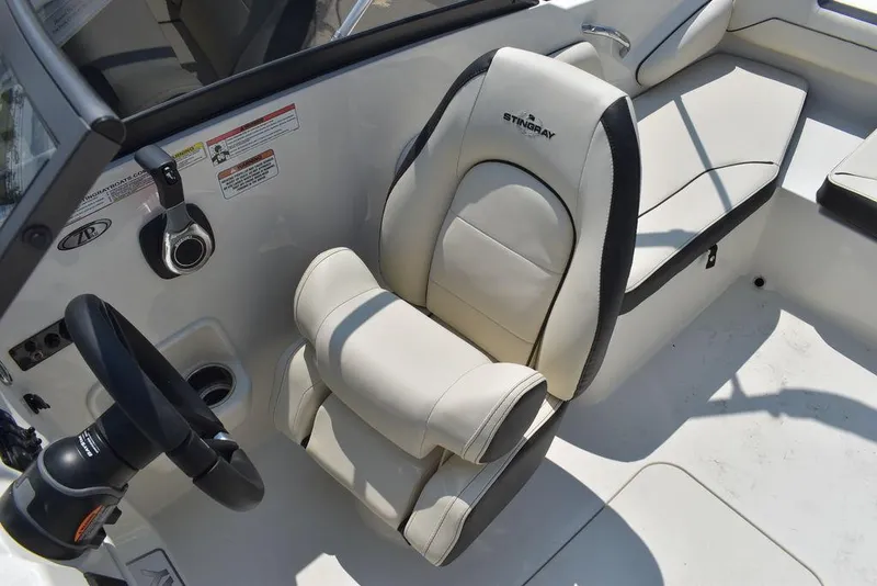 Slide: The Image of 2023 Stingray 191DC boat interior with plush seating and steering wheel. - 30