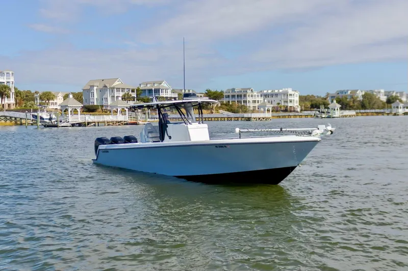 The Image of 2020 Contender 39 ST boat on calm water near coastal homes. - 0