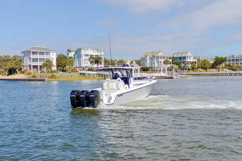 Slide: The Image of 2020 Contender 39 ST boat cruising near waterfront homes. - 3