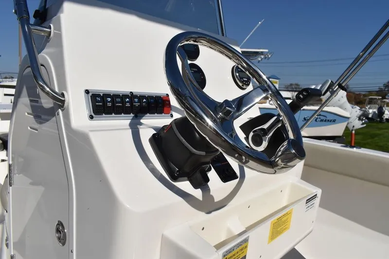 Slide: The Image of 2025 Key West 203 FS boat steering console with chrome wheel and control panel. - 25