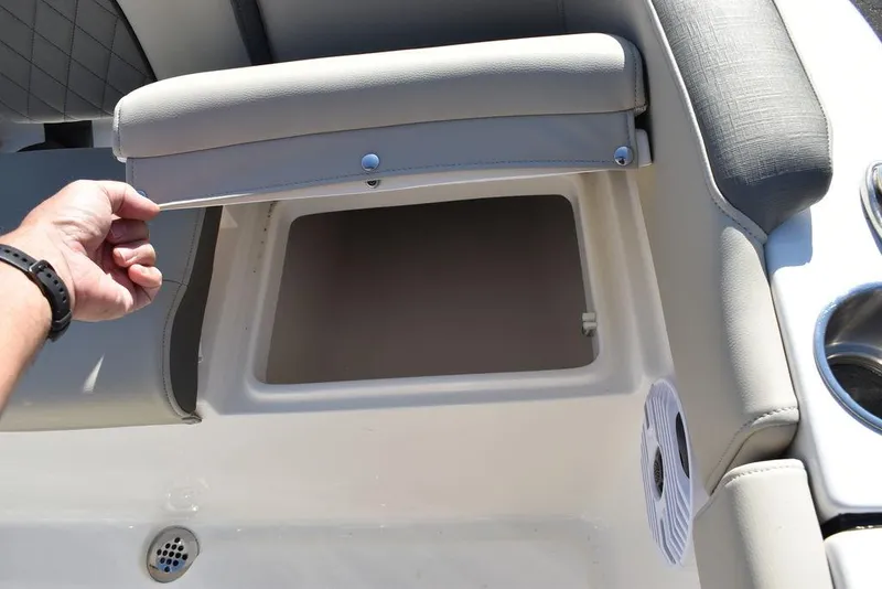 Slide: The Image of 2025 Key West 203 FS boat seat storage compartment with cup holders and speaker. - 34