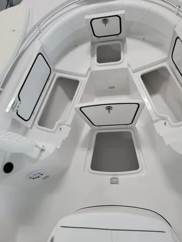 Slide: The Image of 2025 Sportsman Heritage 231 boat storage compartments, white interior, open hatches. - 17
