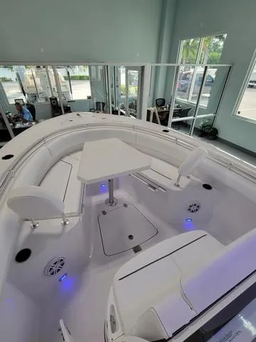 Slide: The Image of 2025 Sportsman Heritage 231 boat interior with seating and table, showroom display. - 22
