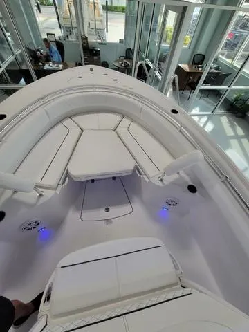 Slide: The Image of 2025 Sportsman Heritage 231 boat interior with white seating and blue LED lights. - 26