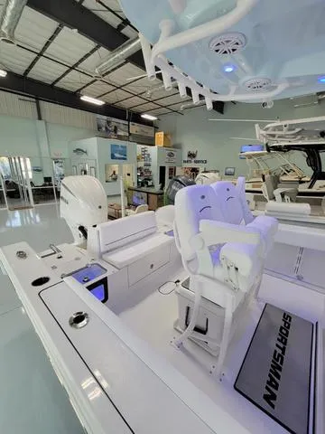 Slide: The Image of 2025 Sportsman Heritage 231 boat interior in showroom, featuring modern seating and controls. - 28