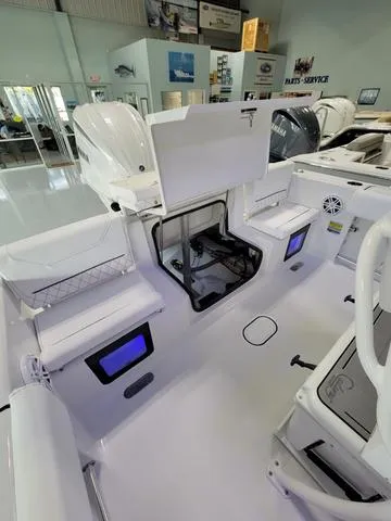 Slide: The Image of 2025 Sportsman Heritage 231 boat interior with open storage compartments in showroom. - 29