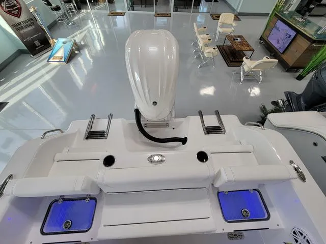 Slide: The Image of 2025 Sportsman Heritage 231 boat interior with seating and motor in showroom. - 31